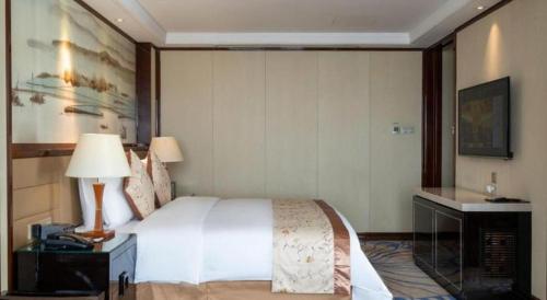 Ένα ή περισσότερα κρεβάτια σε δωμάτιο στο Yang Peng Jin Jiang Hotel