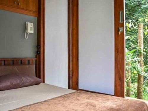 a bedroom with a bed and a phone on the wall at VillaTel Salse in Bandung