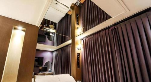 a room with a bed and some curtains at Seven Motel Ansan in Ansan