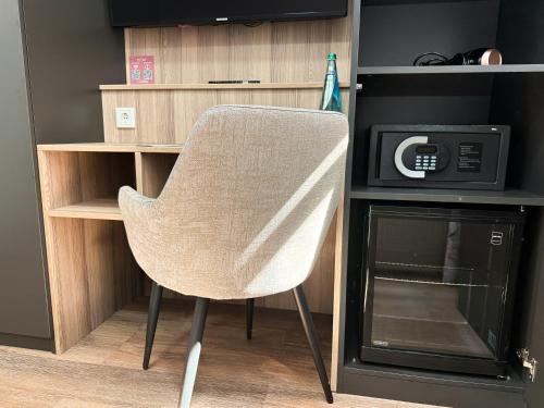 a white chair sitting in front of a microwave at Hey! Halle - Dein Stadthotel in Halle an der Saale