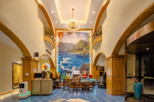 a dining room with a large painting on the wall at 成都吾行东方酒店 in Chengdu