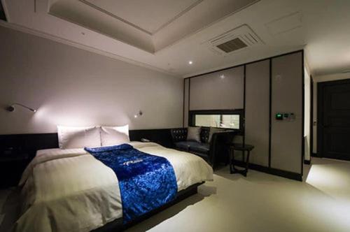 a bedroom with a large bed and a couch at Hotel Floce in Bucheon