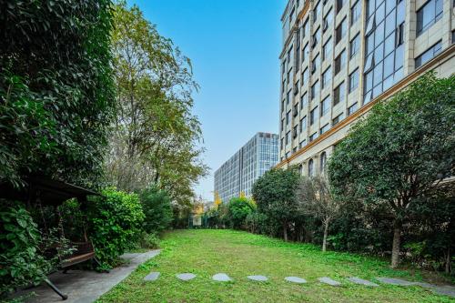 a garden in the middle of a city with buildings at 成都吾行东方酒店 in Chengdu