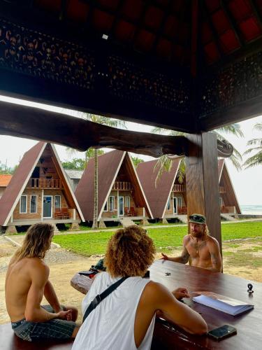 un gruppo di persone sedute a un tavolo davanti alle case di Soluta Resort a Wainapal