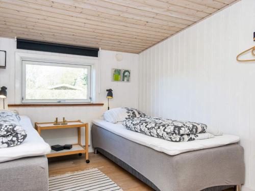 ein Schlafzimmer mit zwei Betten und einem Fenster in der Unterkunft 10 person holiday home in Glesborg-By Traum in Glesborg