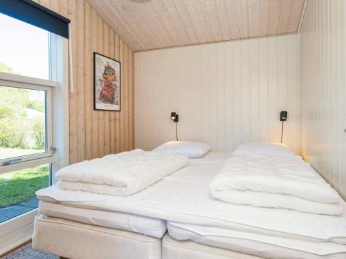 a large white bed in a room with a window at 10 person holiday home in Glesborg-By Traum in Glesborg