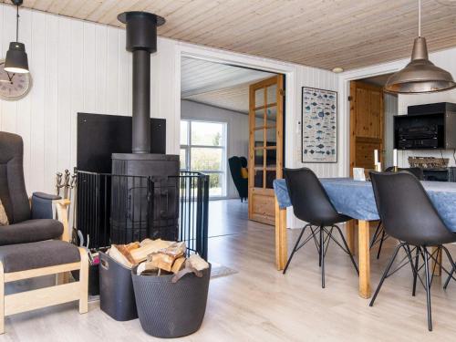 ein Wohnzimmer mit Kamin, Tisch und Stühlen in der Unterkunft 10 person holiday home in Glesborg-By Traum in Glesborg