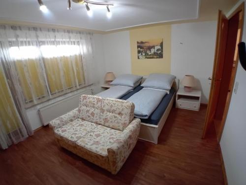 a bedroom with a bed and a couch and a chair at Bayerwald Auszeit in Waldkirchen