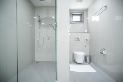 a white bathroom with a shower and a toilet at Maagiri Hotel in Male City