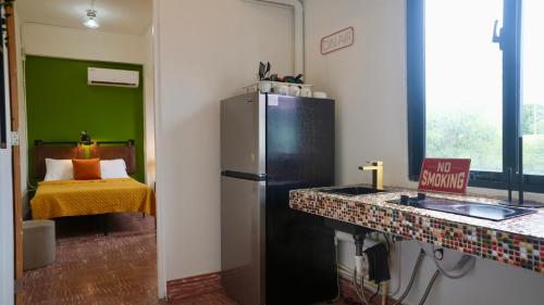 a kitchen with a refrigerator in a room with a bed at 1 & 2 Bedroom Apartments I Calle Loíza by Beach & Nightlife in San Juan