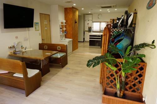 ein Wohnzimmer mit Tisch und Küche in der Unterkunft Okusuruga Guest House - Vacation STAY 14698 in Numazu