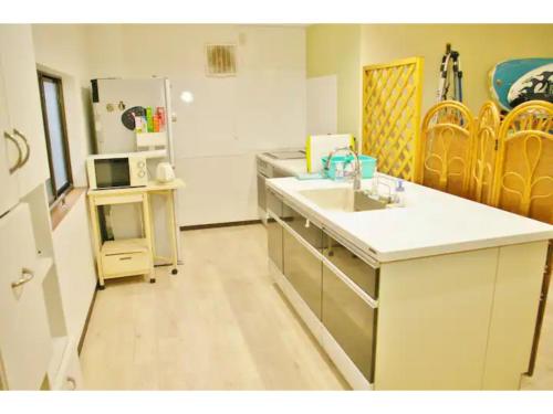 eine Küche mit Spüle und Kühlschrank in der Unterkunft Okusuruga Guest House - Vacation STAY 14698 in Numazu