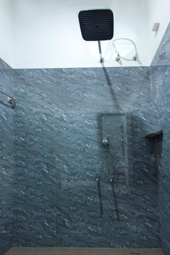 a bathroom with a shower with a glass wall at Anoop's Lake View Cottage -2BHK in Munroe Island