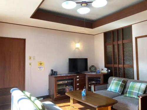 a living room with a couch and a tv at Minpaku Yagi - Vacation STAY 14700 in Ise