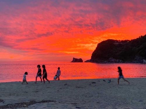 a group of people walking on the beach at sunset at Guesthouse Tide Pool - Vacation STAY 62386v in Amakusa