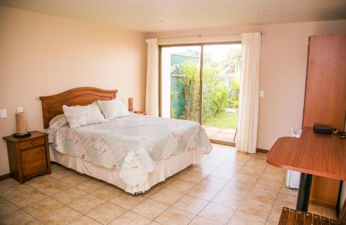 a bedroom with a bed and a large window at Cabañas Las Añañucas V in La Serena