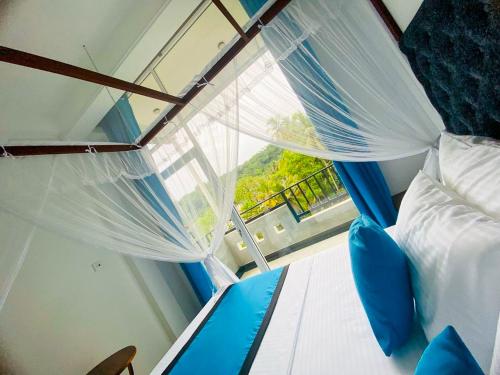 a bedroom with a canopy bed and a window at Camellia Unawatuna in Unawatuna