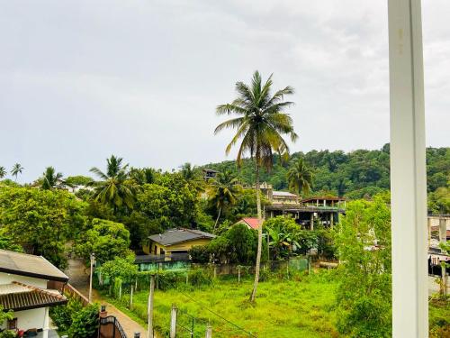 a view of a village with palm trees and houses at Camellia Unawatuna in Unawatuna