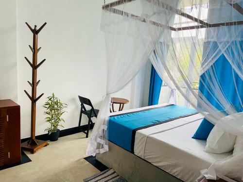 a bedroom with a bed with a mosquito net at Camellia Unawatuna in Unawatuna