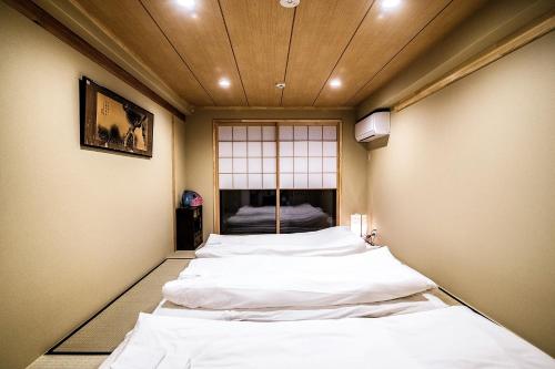 京都市にあるKyomachiya Mitsushi - Vacation STAY 63201vの窓のある部屋に並んだベッド