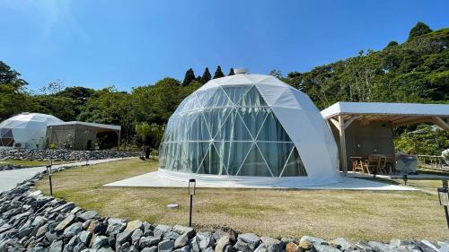 Una gran carpa tipo domo en un campo junto a un edificio. en amazing view room 2 - Vacation STAY 66283v, en Kushima