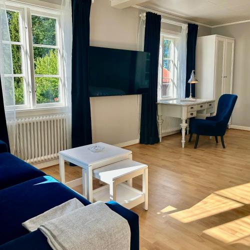 a living room with a blue couch and a desk at West wing, Långnäs Manor in Hofors