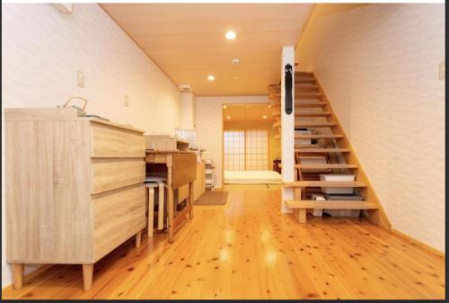 a room with a staircase in a room with wooden floors at Kyomachiya Mitsugetsu - Vacation STAY 63459v in Kyoto