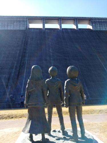 a statue of three women standing in front of a stadium at Kurokawa Onsen Besso - Vacation STAY 14733 in Minamioguni