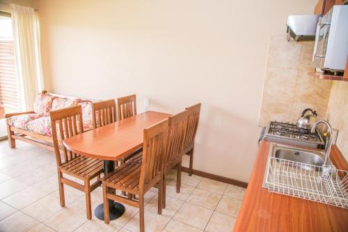 a kitchen with a wooden table and chairs and a couch at Cabañas Las Añañucas V in La Serena