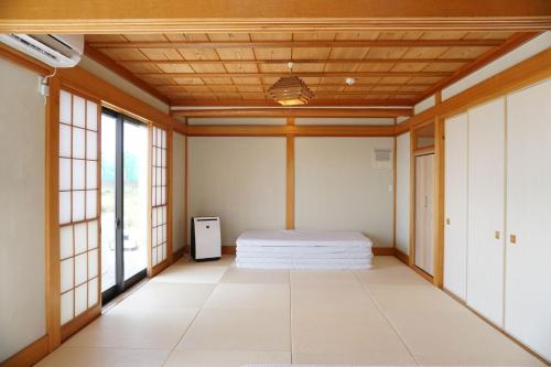 a bedroom with a bed in a room with windows at Ocean Resort Tateyama T House - Vacation STAY 69839v in Tateyama