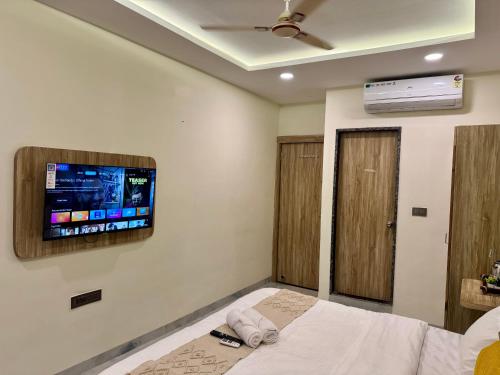 a bedroom with a bed and a tv on the wall at Hotel The Argal By Basotel, Vijay Nagar in Indore