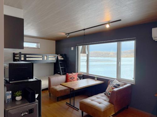 a living room with a bed and a couch and a table at FLEXWORK tawa - Vacation STAY 99885v in Teshikaga
