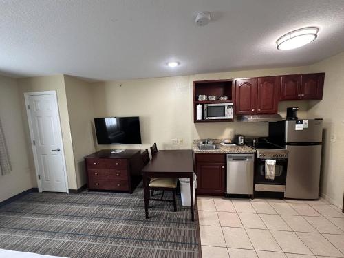 a small kitchen with a table and a stove and microwave at MainStay Suites Coralville - Iowa City in Coralville