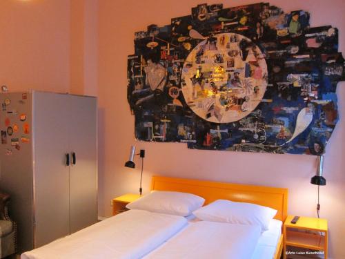 a bedroom with a bed with a painting on the wall at Arte Luise Kunsthotel in Berlin