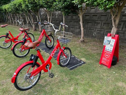 zwei rote Fahrräder sind im Gras geparkt in der Unterkunft Chambord Kyomachi 205 - Vacation STAY 69095v in Kumamoto