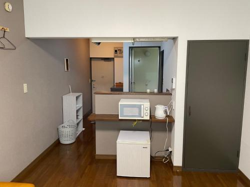 eine Küche mit einer Arbeitsfläche, auf der eine Mikrowelle steht in der Unterkunft Chambord Kyomachi 205 - Vacation STAY 69095v in Kumamoto