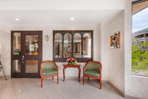 a lobby with two chairs and a table with flowers at Quality Hotel Fallsview Cascade in Niagara Falls