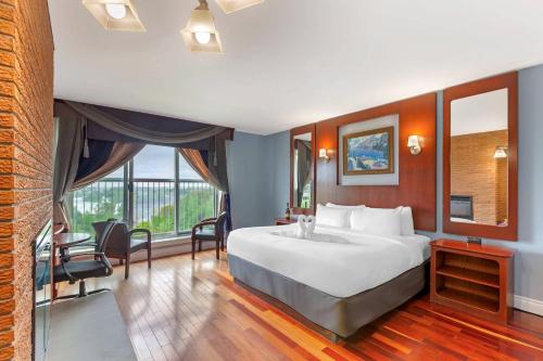 Una habitación de hotel con una cama grande y una ventana grande. en Quality Hotel Fallsview Cascade, en Niagara Falls