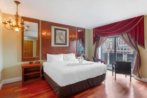 a hotel room with a large bed and a window at Quality Hotel Fallsview Cascade in Niagara Falls