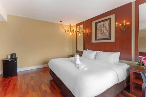 a hotel room with a large white bed in it at Quality Hotel Fallsview Cascade in Niagara Falls