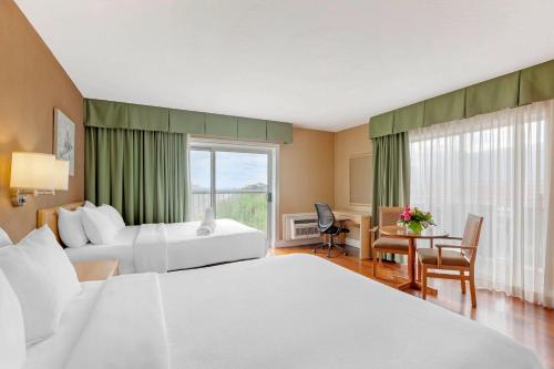 a hotel room with two beds and a window at Quality Hotel Fallsview Cascade in Niagara Falls