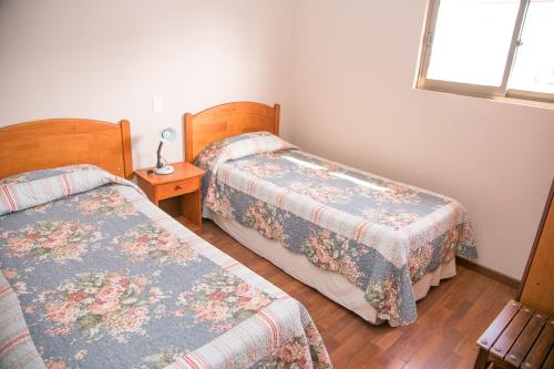 a bedroom with two beds and a window at Cabañas Las Añañucas V in La Serena