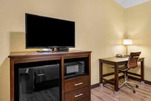 a room with a tv and a desk with a chair at Econo Lodge Inn & Suites in Eau Claire