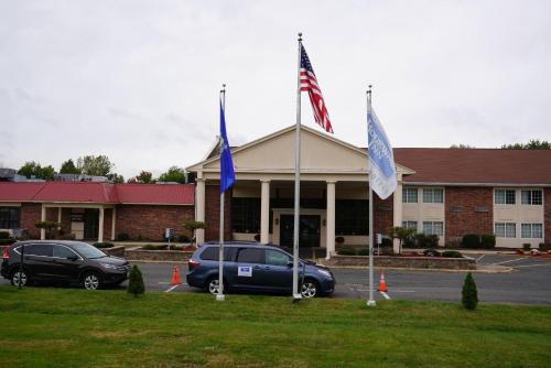 East WindsorにあるRodeway Inn & Suites East Windsorの建物前駐車場二旗