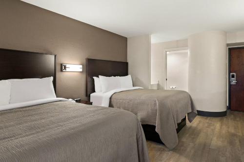 a hotel room with two beds with white sheets at Quality Inn in Lavonia