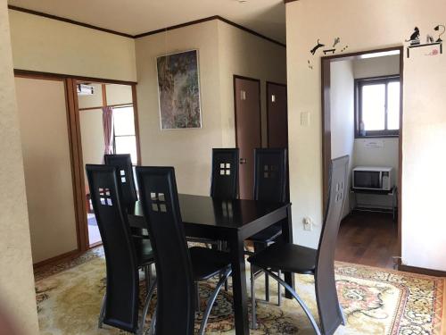 a dining room with a black table and chairs at Marine View Shimane - Vacation STAY 78823v in Matsue