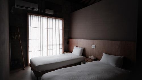 Dos camas en una habitación con ventana. en Mud - Vacation STAY 71384v, en Ishigaki Island