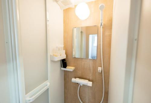 a bathroom with a shower and a mirror at Ezo Fujiya Niseko House - Vacation STAY 14768 in Kutchan