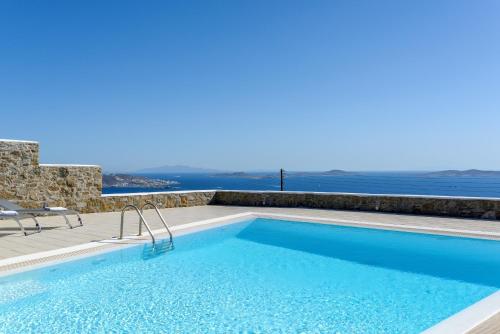 a swimming pool with a view of the ocean at Sunset Villa in Houlakia