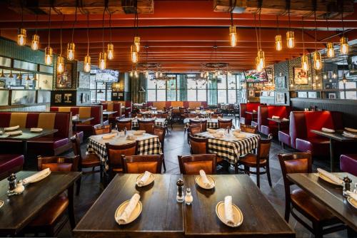 a restaurant with tables and chairs in a room at Cambria Hotel College Park in College Park